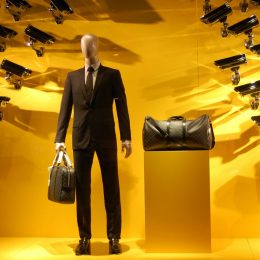 Eine Schaufensterpuppe mit zwei Taschen auf die unzählige Kameras gerichtet sind