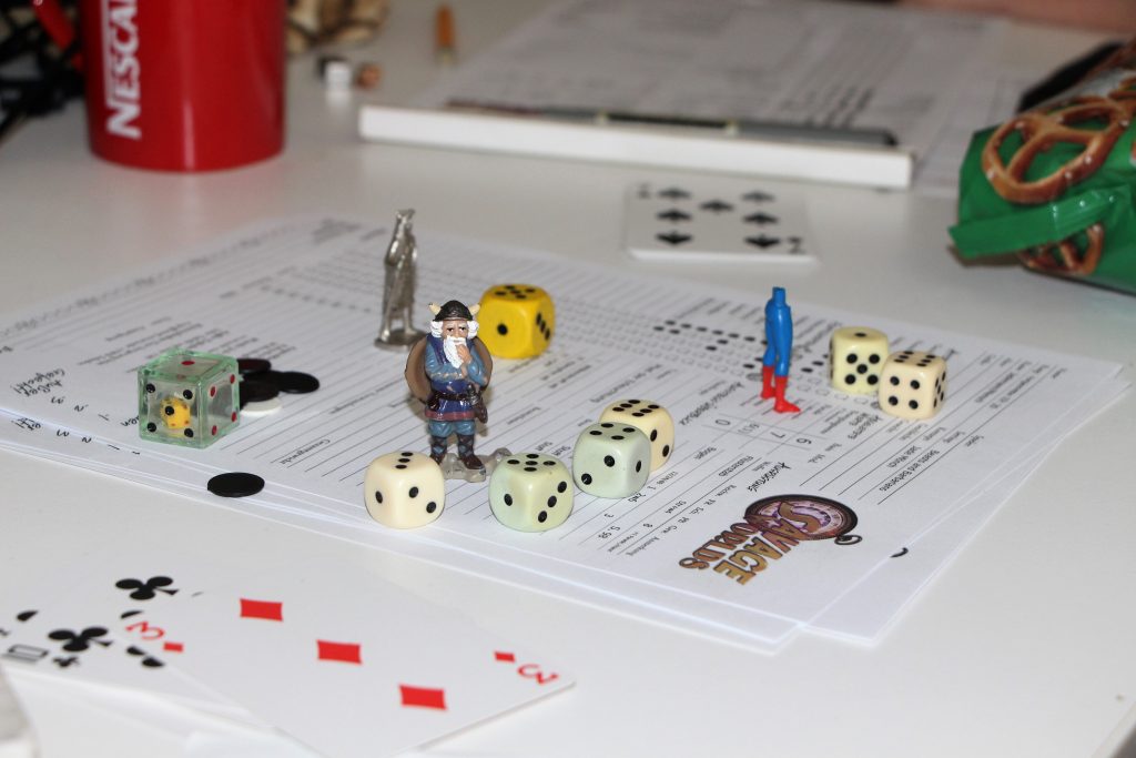 Spielfiguren und Würfel für einen Kampf in Savage Worlds aufgestellt